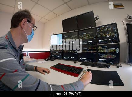 Darmstadt, Deutschland. 17th. November 2021. Holger Kötting, technischer Leiter des Systems im Darmstädter Eisenbahnverkehrsbereich (EBD), sitzt wie in modernen Signalboxen an den Monitoren und steuert die Punkte, Signale und Züge auf dem damit verbundenen Modellbahnsystem. Das Simulationssystem soll möglichst viele verschiedene Betriebssituationen auf der realen Bahn realistisch reproduzieren. (To dpa 'Training mit Spielzeuglokomotive - Modelleisenbahn hilft bei der Verzahnung') Quelle: Frank Rumpenhorst/dpa/Alamy Live News Stockfoto