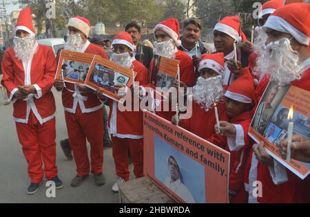 Lahore, Pakistan. 21st Dez 2021. Pakistanische Aktivisten der Bright Future Society und der IMRF tragen die Kostüme des Weihnachtsmannes, halten Plakate und zünden Kerzen an während der Demonstration an, um Solidarität mit der Familie der srilankischen Managerin Priyantha Kumara vor dem Presseclub in Lahore zu zeigen. Quelle: Pacific Press Media Production Corp./Alamy Live News Stockfoto