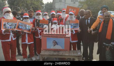 Lahore, Pakistan. 21st Dez 2021. Pakistanische Aktivisten der Bright Future Society und der IMRF tragen die Kostüme des Weihnachtsmannes, halten Plakate und zünden Kerzen an während der Demonstration an, um Solidarität mit der Familie der srilankischen Managerin Priyantha Kumara vor dem Presseclub in Lahore zu zeigen. Quelle: Pacific Press Media Production Corp./Alamy Live News Stockfoto