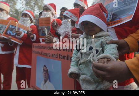 Lahore, Pakistan. 21st Dez 2021. Pakistanische Aktivisten der Bright Future Society und der IMRF tragen die Kostüme des Weihnachtsmannes, halten Plakate und zünden Kerzen an während der Demonstration an, um Solidarität mit der Familie der srilankischen Managerin Priyantha Kumara vor dem Presseclub in Lahore zu zeigen. Quelle: Pacific Press Media Production Corp./Alamy Live News Stockfoto