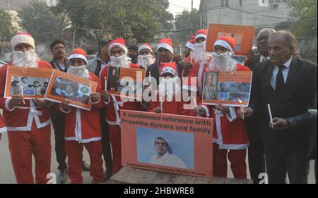 Lahore, Pakistan. 21st Dez 2021. Pakistanische Aktivisten der Bright Future Society und der IMRF tragen die Kostüme des Weihnachtsmannes, halten Plakate und zünden Kerzen an während der Demonstration an, um Solidarität mit der Familie der srilankischen Managerin Priyantha Kumara vor dem Presseclub in Lahore zu zeigen. Quelle: Pacific Press Media Production Corp./Alamy Live News Stockfoto