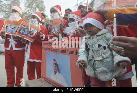 Lahore, Pakistan. 21st Dez 2021. Pakistanische Aktivisten der Bright Future Society und der IMRF tragen die Kostüme des Weihnachtsmannes, halten Plakate und zünden Kerzen an während der Demonstration an, um Solidarität mit der Familie der srilankischen Managerin Priyantha Kumara vor dem Presseclub in Lahore zu zeigen. Quelle: Pacific Press Media Production Corp./Alamy Live News Stockfoto