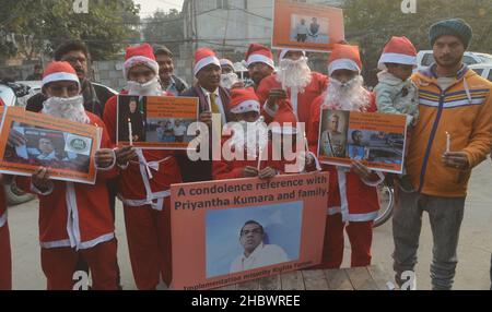 Lahore, Pakistan. 21st Dez 2021. Pakistanische Aktivisten der Bright Future Society und der IMRF tragen die Kostüme des Weihnachtsmannes, halten Plakate und zünden Kerzen an während der Demonstration an, um Solidarität mit der Familie der srilankischen Managerin Priyantha Kumara vor dem Presseclub in Lahore zu zeigen. Quelle: Pacific Press Media Production Corp./Alamy Live News Stockfoto