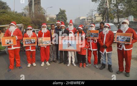 Lahore, Pakistan. 21st Dez 2021. Pakistanische Aktivisten der Bright Future Society und der IMRF tragen die Kostüme des Weihnachtsmannes, halten Plakate und zünden Kerzen an während der Demonstration an, um Solidarität mit der Familie der srilankischen Managerin Priyantha Kumara vor dem Presseclub in Lahore zu zeigen. Quelle: Pacific Press Media Production Corp./Alamy Live News Stockfoto
