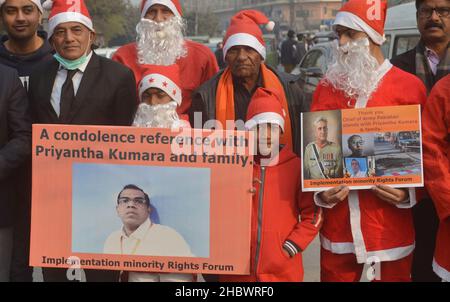 Lahore, Pakistan. 21st Dez 2021. Pakistanische Aktivisten der Bright Future Society und der IMRF tragen die Kostüme des Weihnachtsmannes, halten Plakate und zünden Kerzen an während der Demonstration an, um Solidarität mit der Familie der srilankischen Managerin Priyantha Kumara vor dem Presseclub in Lahore zu zeigen. Quelle: Pacific Press Media Production Corp./Alamy Live News Stockfoto