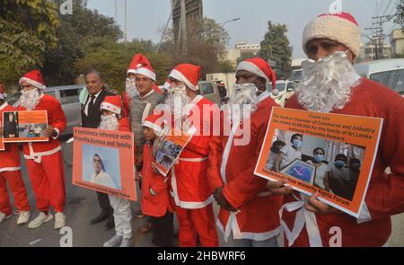 Lahore, Pakistan. 21st Dez 2021. Pakistanische Aktivisten der Bright Future Society und der IMRF tragen die Kostüme des Weihnachtsmannes, halten Plakate und zünden Kerzen an während der Demonstration an, um Solidarität mit der Familie der srilankischen Managerin Priyantha Kumara vor dem Presseclub in Lahore zu zeigen. Quelle: Pacific Press Media Production Corp./Alamy Live News Stockfoto