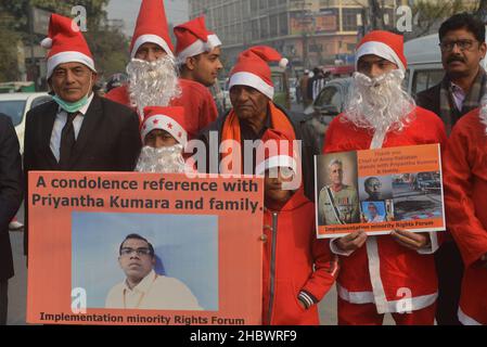 Lahore, Pakistan. 21st Dez 2021. Pakistanische Aktivisten der Bright Future Society und der IMRF tragen die Kostüme des Weihnachtsmannes, halten Plakate und zünden Kerzen an während der Demonstration an, um Solidarität mit der Familie der srilankischen Managerin Priyantha Kumara vor dem Presseclub in Lahore zu zeigen. Quelle: Pacific Press Media Production Corp./Alamy Live News Stockfoto