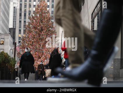 New York, Usa. 21st Dez 2021. Fußgänger gehen am Dienstag, dem 21. Dezember 2021, am Weihnachtsbaum des Rockefeller Center in New York City vorbei. New York verzeichnet weiterhin Rekorde für positive COVID-Fälle, da die Urlaubsreisen immer weiter ansteigen. Foto von John Angelillo/UPI Credit: UPI/Alamy Live News Stockfoto