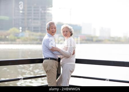 Glückliches altes Paar, das am Fluss entlang läuft Stockfoto