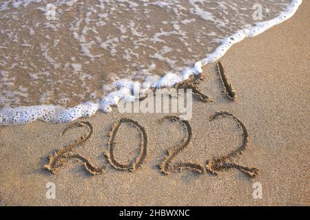 2021, 2022 Jahre geschrieben am Sandstrand Meer. Welle spült weg 2021. Stockfoto