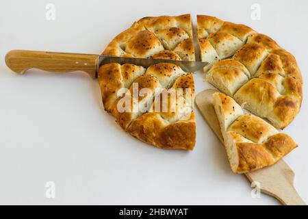 Triangle Sliced Turkish Ramadan Bread, Pide auf weißer Oberfläche mit Spachtel und Messer. Stockfoto