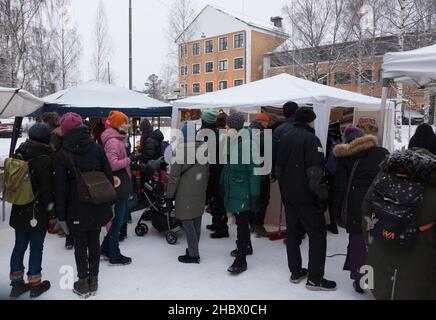 Umea, Norrland Schweden - 11. Dezember 2021: Wintergekleidete Menschen auf dem Weihnachtsmarkt Stockfoto