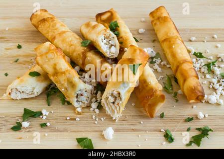 Traditionelle türkische Sigara Borek, kitschig, kitschig und herzhaft große Vorspeisen Fingerfood auf dem Schneidebrett. Stockfoto