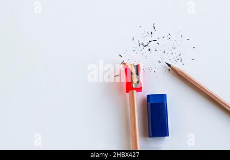 Naturholzstifte mit rotem Spitzer und blauem Gummi auf der weißen Oberfläche.konzeptuelles Bild von Bildung. Stockfoto