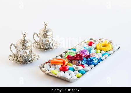 Bunte Mandelbonbons und Schokolade auf einem Vintage-Tablett mit traditionellem türkischen Kaffee Stockfoto