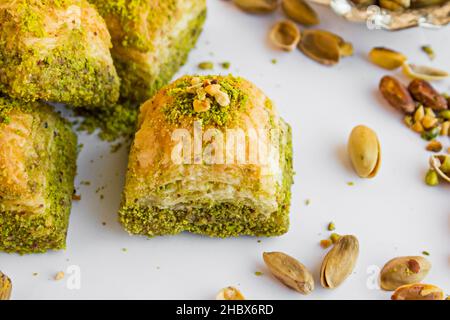 Traditionelle türkische Konditorei Dessert trockene Pistazien Baklava, ausgewählt eine Scheibe auf der weißen Oberfläche mit Pistazien-Nüssen Stockfoto