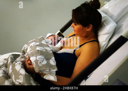 Eine Mutter hält ihr neugeborenes Baby auf der Arbeitsstation im King's College Hospital im Südosten Londons. Bilddatum: Dienstag, 21. Dezember 2021. Stockfoto