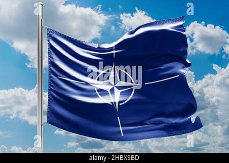 NATO-Flagge winkt vom Wind Stockfoto