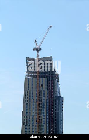 Ein sehr hoher Jib-Kran auf einer hohen Gebäudekonstruktion. Stockfoto