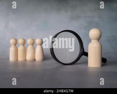 Selektives Fokusbild von Vergrößerungsglas und Holzpuppen mit Kopierraum. Unternehmensrekrutierung, Stelleneinstellung, Inspektion und Suchkonzept Stockfoto