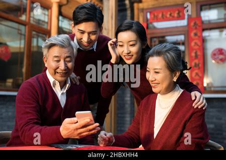 Glückliche Familie mit Smartphones im neuen Jahr Stockfoto