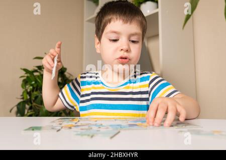 Ein Vorschulkinder spielt Puzzles, stellt ein Bild zusammen Stockfoto
