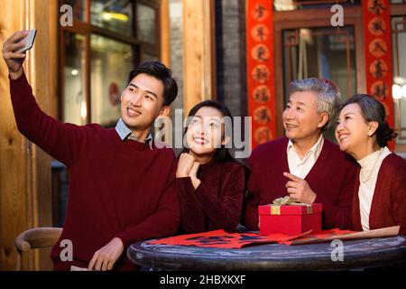 Glückliche Familien, die mit ihrem Telefon NeujahrsSelfies machen Stockfoto