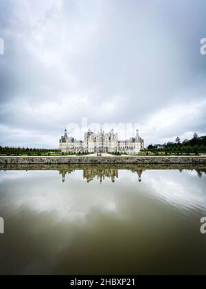 Weitwinkelansicht des Schlosses von Chambord im Loire-Tal, mit seinen Gärten, Bewölkt Tag, Wasserspiegelung, Frankreich Stockfoto