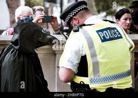 Die Polizei durchsucht Tieraufständler, der als Pestarzt gekleidet ist, in der Nähe der Downing Street London 2020 Stockfoto
