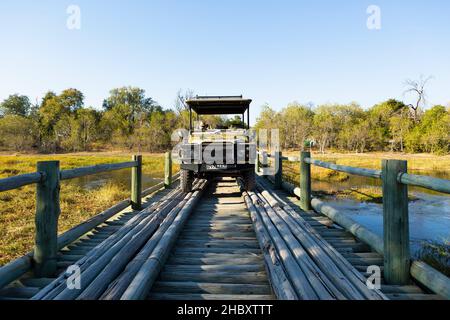 Ein Junge, der über eine Holzbrücke über ein Sumpfgebiet läuft. Stockfoto