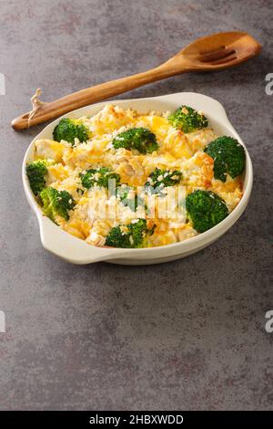 Chicken Divan ist ein cremiger Auflauf, der traditionell mit einem Huhn, Brokkoli, Creme, Käse in der Nähe in der Schale auf dem alten Tisch gemacht. Vertikal Stockfoto