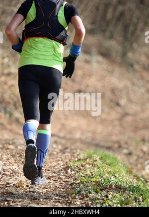 Athletic Runner während des Marathons mitten im Wald im Herbst Stockfoto