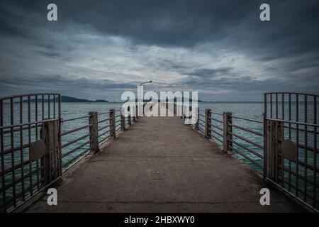 Eine wunderschöne Aufnahme eines Piers auf einem Meer unter dem wolkenlosen Himmel in Rawai Beach, Phuket Stockfoto