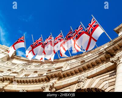 Die weiße Flagge der Royal Navy, die vom Admiralty Arch in London, England, Großbritannien, fliegt, ist ein beliebtes Touristenreiseziel und ein beliebtes Ziel für Touristen Stockfoto