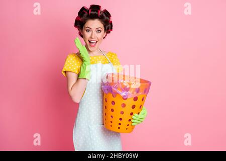 Portrait von schönen attraktiven fröhlich fröhlich fröhlich fröhlich fröhlich braunhaarigen Mädchen hält in den Händen Papierkorb über rosa Pastellfarben Hintergrund isoliert Stockfoto