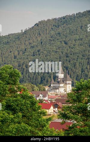 Gura Humorului, Rumänien - 07 13 2020 Ansicht einer orthodoxen Kirche, in der Bergstadt durch das Laub Stockfoto