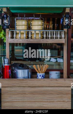 Vorderansicht Vintage-Stil Nudel Shop Ton. Holzthekendisplay vor dem Restaurant mit Pinto, Keramikschalen, Essstäbchen aus Holz, Edelstahl Stockfoto