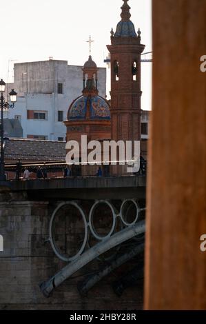 Triana Viertel in Sevilla über die Puente de Isabel II Brücke und Neo-Mudéjar Kapelle von El Carmen. Stockfoto