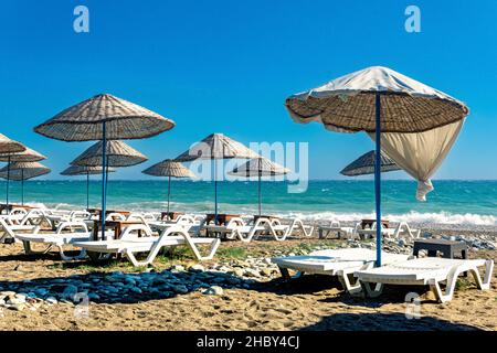 Der Strand mit Sonnenschirmen und Liegestühlen ist während eines Sturms leer Stockfoto
