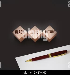 Text von BLM bedeutet, dass Black Lives Matter auf Holzblöcken auf schwarzem Hintergrund geschrieben ist. Stockfoto