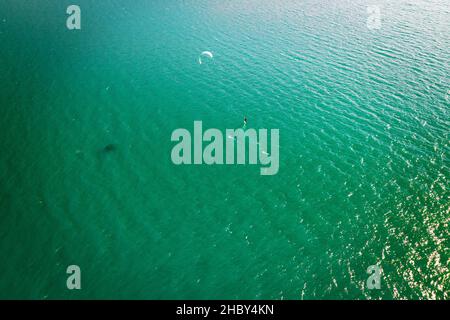 Kitesurfer in Aktion auf smaragdgrünem Wasser, Luftaufnahme Stockfoto