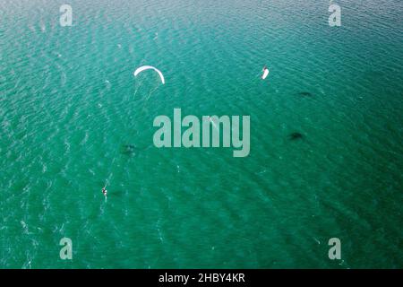 Kitesurfer in Aktion auf smaragdgrünen Wasser, Luft Stockfoto