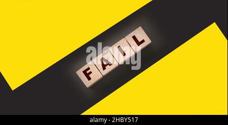FAIL Word-Text in Holzwürfelblöcken auf schwarzem Hintergrund geschrieben. Krisenkonzept Stockfoto