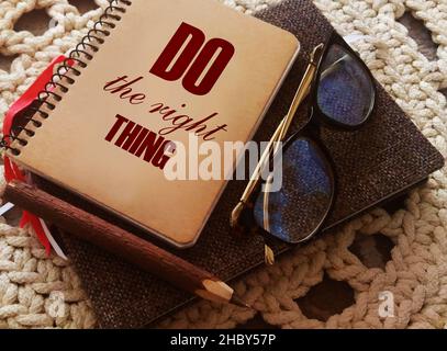 Text tun die richtigen Dinge Worte auf dem Cover von Notebook, Brille und Stift. Konzept zur beruflichen Motivation Stockfoto