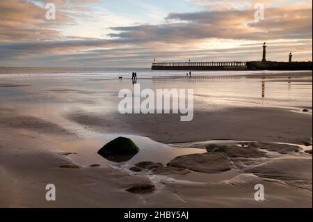 Spaziergänger am frühen Morgen am Strand, Whitby, North Yorkshire, Großbritannien Stockfoto