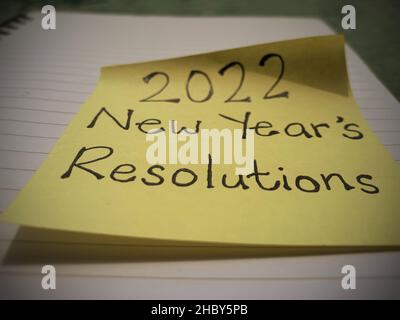 2022 Vorsätze zum neuen Jahr auf einer Haftnotiz mit verschwommenem Hintergrund geschrieben Stockfoto