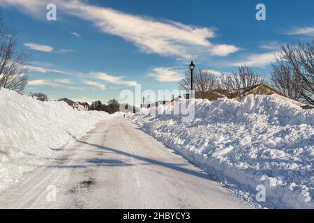 Gepflügte Straße durch eine Unterteilung nach einem Sturm. Stockfoto