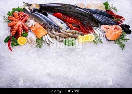 Meeresfrüchte-Rohstoff mit Blick von oben auf das Eis. Draufsicht gefrorene mediterrane Lebensmittel und eingefeiste Kräuter wie Zitrone, Dill, Petersilie. Stockfoto