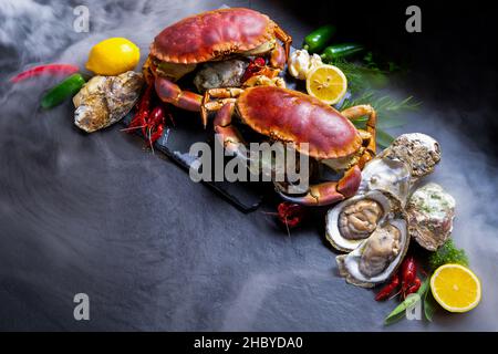 Meeresfrüchte würzen Lebensmittel mit Steinkrebsen. Auswahl der Zutat für das Kochen im Restaurant.Draufsicht auf frischen Stoff Hintergrund. Stockfoto