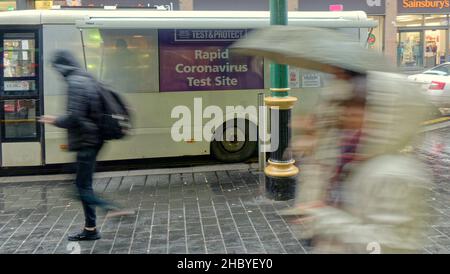 Glasgow, Schottland, Vereinigtes Königreich 22nd. Dezember 2021. Wetter in Großbritannien: Auf den nassen Weihnachtsstraßen kämpfen die Einheimischen im Regen mit weihnachtlichen Zeichen rund um sie herum.der Hauptbahnhof sah kovide Tester in Forve als getarnter Veranstaltungsort für Informationen..Credit Gerard Ferry/Alamy Live News Stockfoto